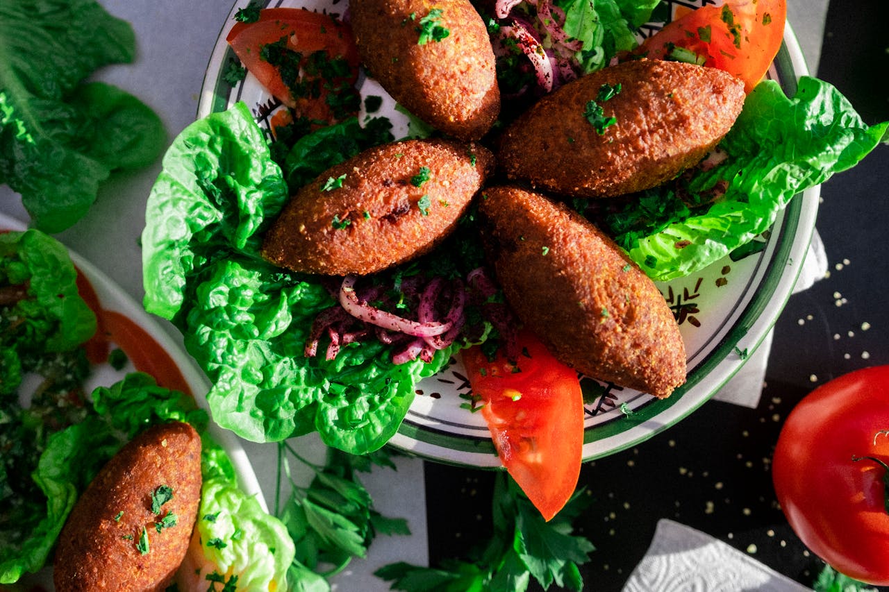 about-us-01 Delicious Lebanese kibbeh served on a bed of fresh greens and vegetables.